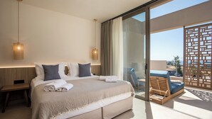 Una habitación de hotel moderna con una cama grande, dos lámparas de noche, un balcón con vistas y una mesita de noche de madera.
