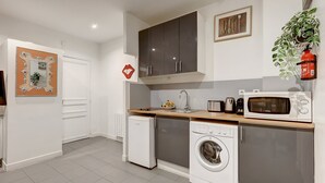 Cocina compacta con lavadora, microondas y tostadora.
