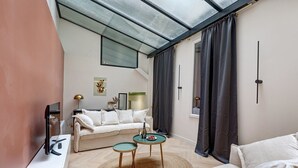 A modern living room with a sofa, coffee table, and a TV. - TBS 174 - Exceptional flat in the heart of Paris (Paris)