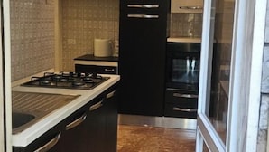 A modern kitchen with a gas stove, black cabinetry, and a built-in oven.