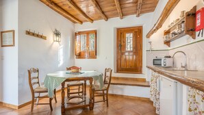 A kitchen with a wooden table, chairs, a microwave, and a sink.