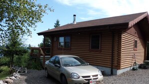 A log cabin with a car parked in front. - Cozy log cabin with fantastic views and 2 bathrooms (The Points West Bay)
