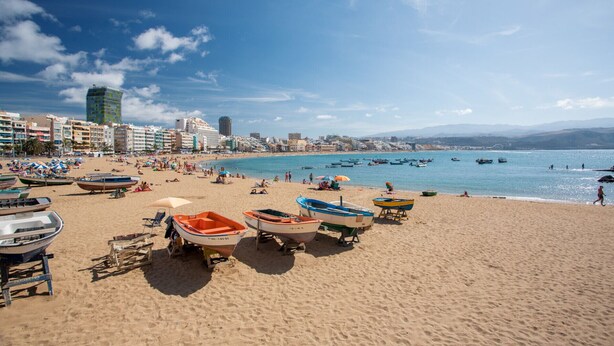 A beach with boats and umbrellas, a clear sky, and buildings in the background. - Confital Beach Home  By CanariasGetaway (Las Palmas de Gran Canaria)