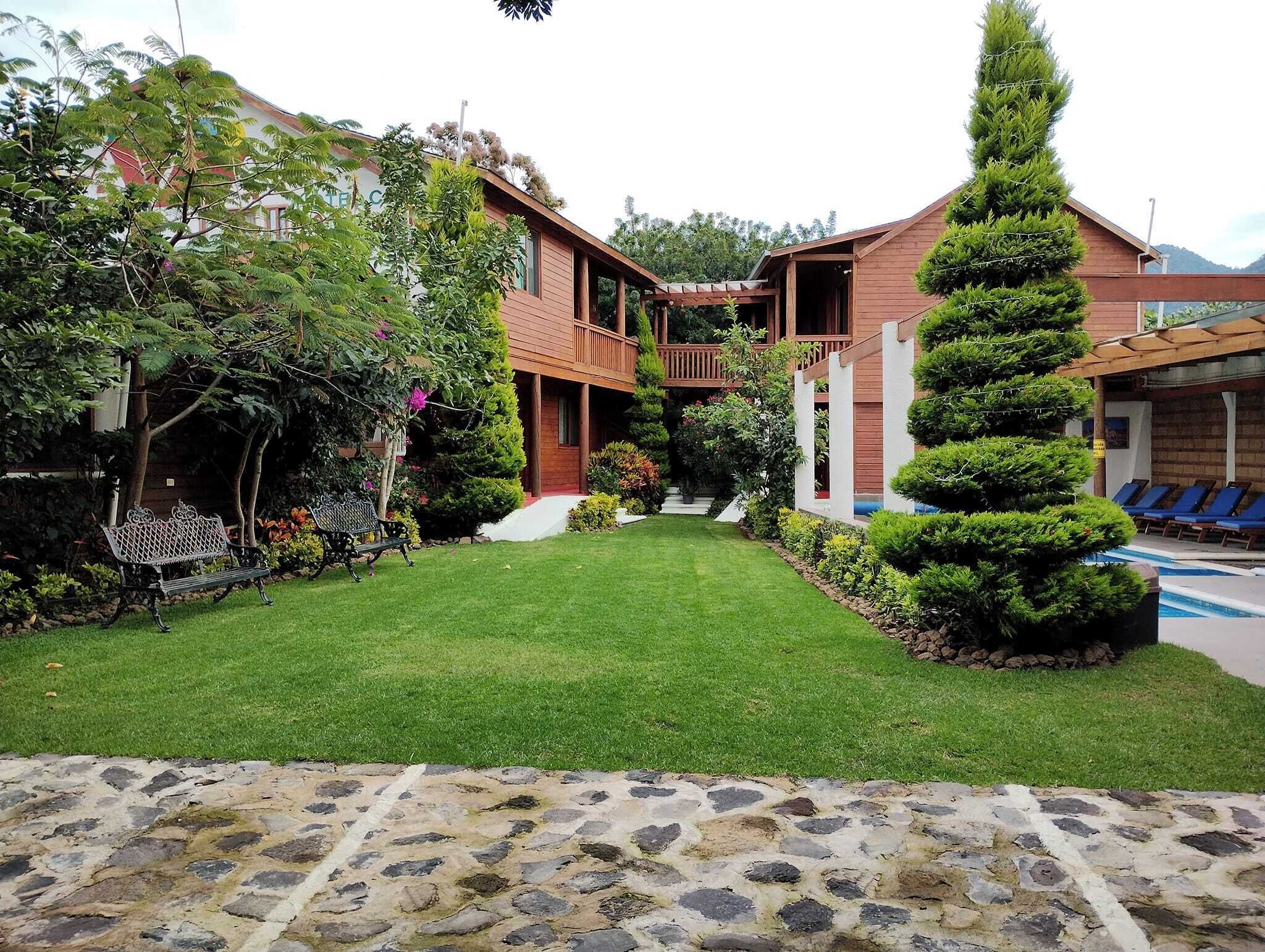 A two-story building with a covered outdoor area, a swimming pool, and a well-maintained lawn.