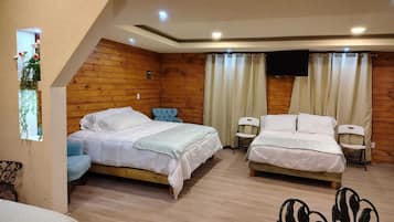Un dormitorio con dos camas, paredes de madera, una ventana pequeña con plantas y una lámpara en el techo.