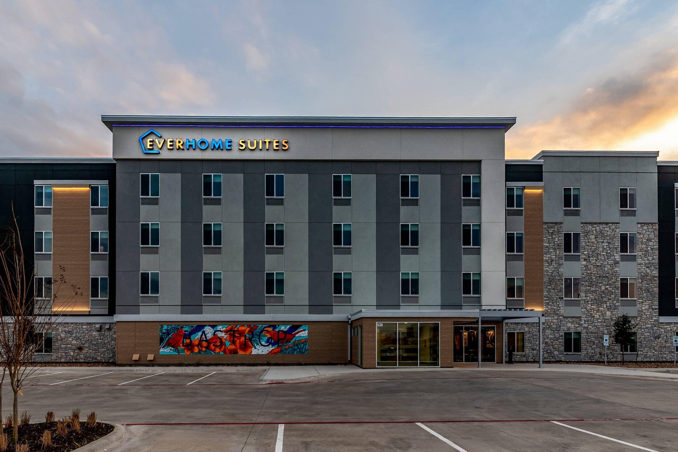 Un moderno edificio de hotel con un cartel que dice "Everhome Suites".