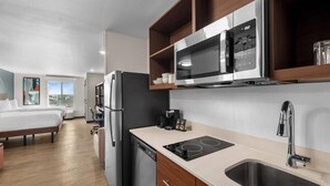 A modern kitchen with a built-in microwave, stove, and sink. - Everhome Suites Bastrop By Choice Hotels (Bastrop)