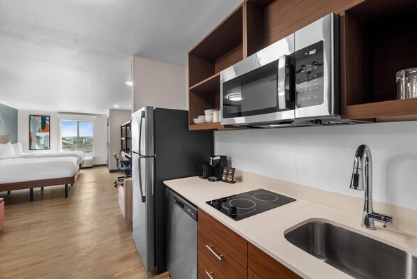 A modern kitchen with a built-in microwave, stove, and sink. - Everhome Suites Bastrop By Choice Hotels (Bastrop)