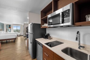 Enjoy a compact and functional space with a kitchenette, bed, and large window offering a view of the outdoors.