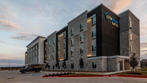 A modern hotel building with a stone facade and multiple windows. - Everhome Suites Bastrop By Choice Hotels (Bastrop)
