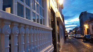 A street view with a building featuring a white facade and a decorative balustrade. - Hotel Miranda (Querétaro)