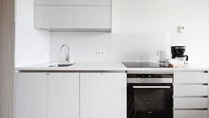 A modern kitchen with a built-in dishwasher, a coffee maker, and a microwave. - OLA LIVING BOQUERIA 5 (Barcelona)
