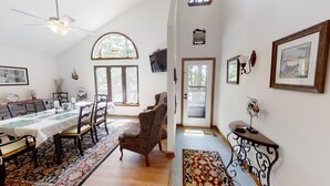 Amplia sala de estar con comedor, ventanas grandes y vistas al exterior.