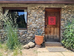 Un edificio rústico de piedra con una puerta de madera y una ventana.