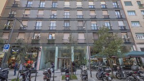 A multi-story building with a modern facade, balconies, and a ground-level entrance with a glass door. - Corso Garibaldi - Modern & Cozy Suite by Rentopolis (Milan)