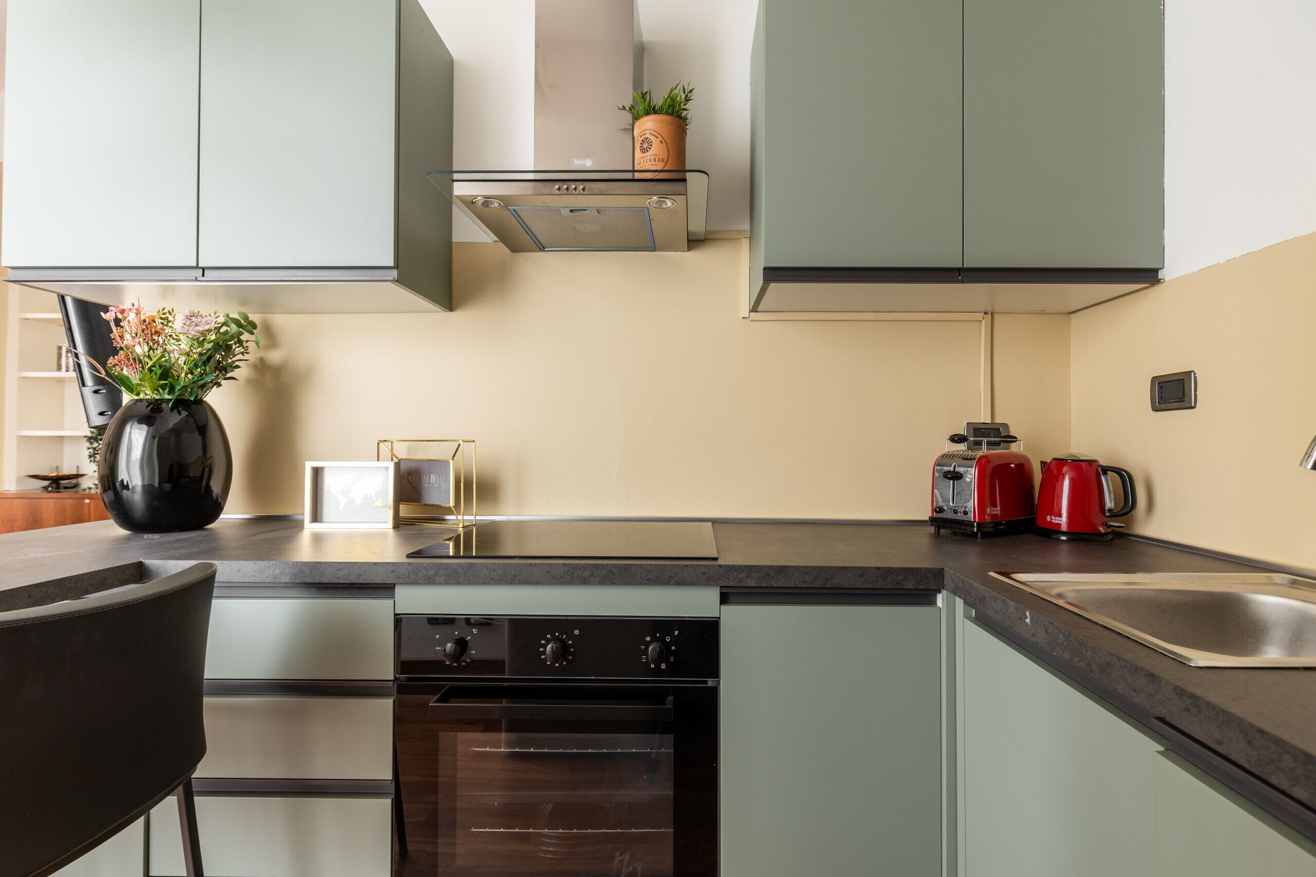 A modern kitchen with a built-in oven, a coffee maker, and a toaster.