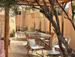 An outdoor patio with wicker furniture, a table, and chairs.