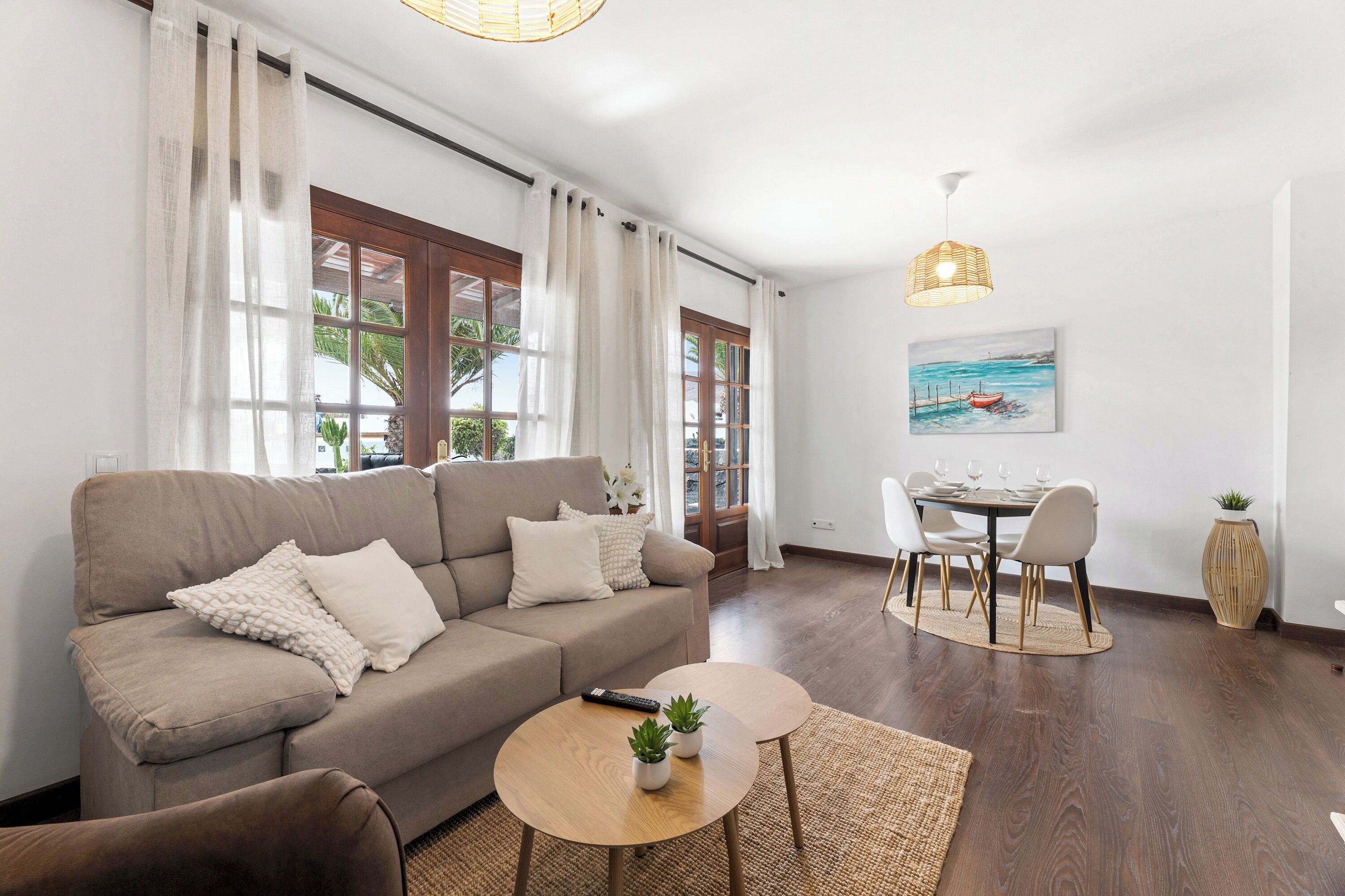 Ein Wohnzimmer mit einer Couch, einem Couchtisch und einem Essbereich mit Stühlen und einem Tisch.