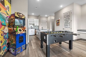 Relax and unwind in this spacious room, featuring a foosball table, arcade machines, and a fully equipped kitchen.