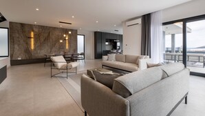 Un salon moderne avec un mur en marbre, un canapé, un coin repas et une vue sur la ville.