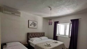 Um quarto com uma cama de solteiro, uma mesa de cabeceira, cortinas na janela e uma ilustração de zebra na parede.