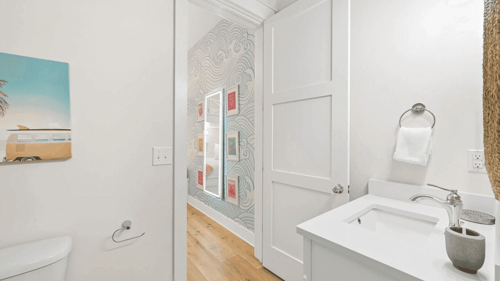 A bathroom with a white sink, a towel rack, and a mirror.
