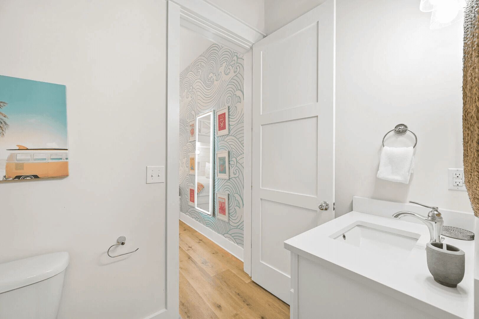 Une salle de bain avec un lavabo blanc, un porte-serviettes et un miroir.