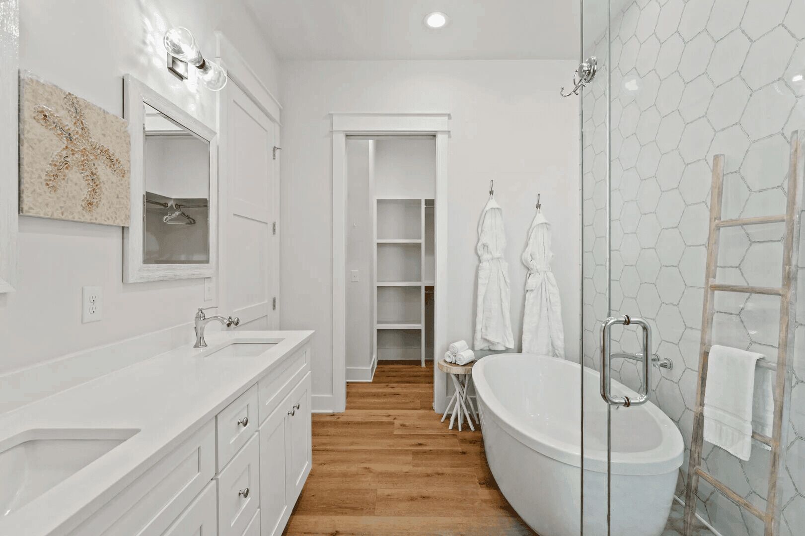 Une salle de bain moderne avec une baignoire sur pieds, une douche à parois de verre et un meuble-lavabo doté d’un grand miroir.
