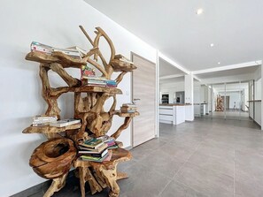 Experience the unique art installation featuring a sculptural tree with books, set amidst a clean, minimalist space.