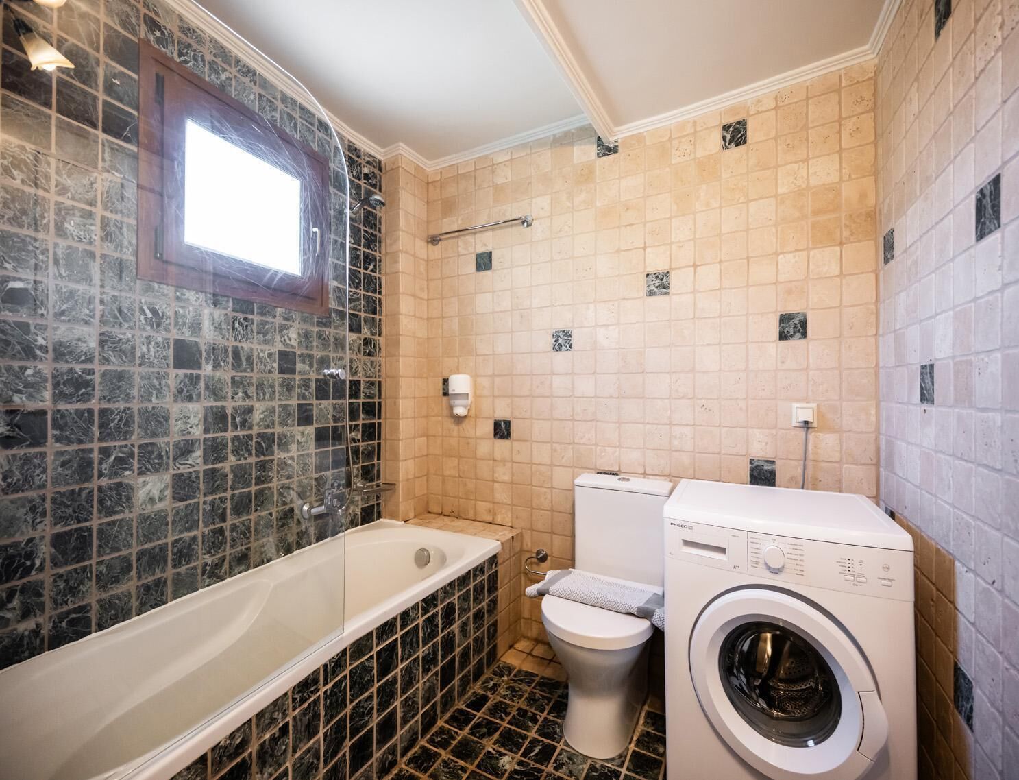 Un bagno con vasca, water e lavatrice.
