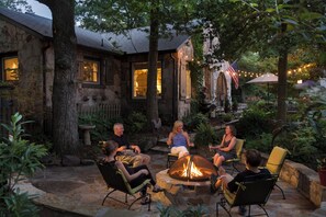 A stone house with a fire pit in the center, surrounded by outdoor seating. - Chanticleer Inn Bed & Breakfast (Lookout Mountain)