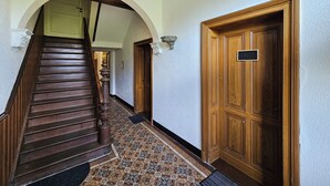 Una escalera de madera con suelo estampado que conduce a una puerta con una placa.