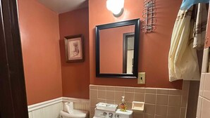 Een badkamer met toilet, wastafel en spiegel.