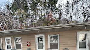 A small, single-story building with numbered doors, outdoor seating, and a fire extinguisher.