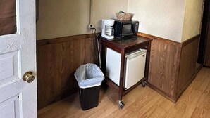 Une petite cuisine équipée d’un four à micro-ondes, d’une machine à café et d’un mini-réfrigérateur.