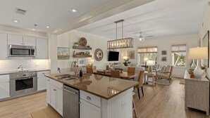 A spacious kitchen with a large island, built-in appliances, and a dining area with a view. - 30A Kinda Day by Avantstay Pool + Private Beach Top Floor Redfish (Santa Rosa Beach)