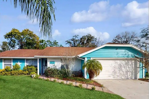 A two-story house with a blue and white exterior, a garage, and a well-maintained lawn. - The blue house
(Spring Hill)