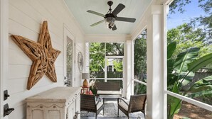 A covered porch with wicker furniture, a star decoration, and a ceiling fan.