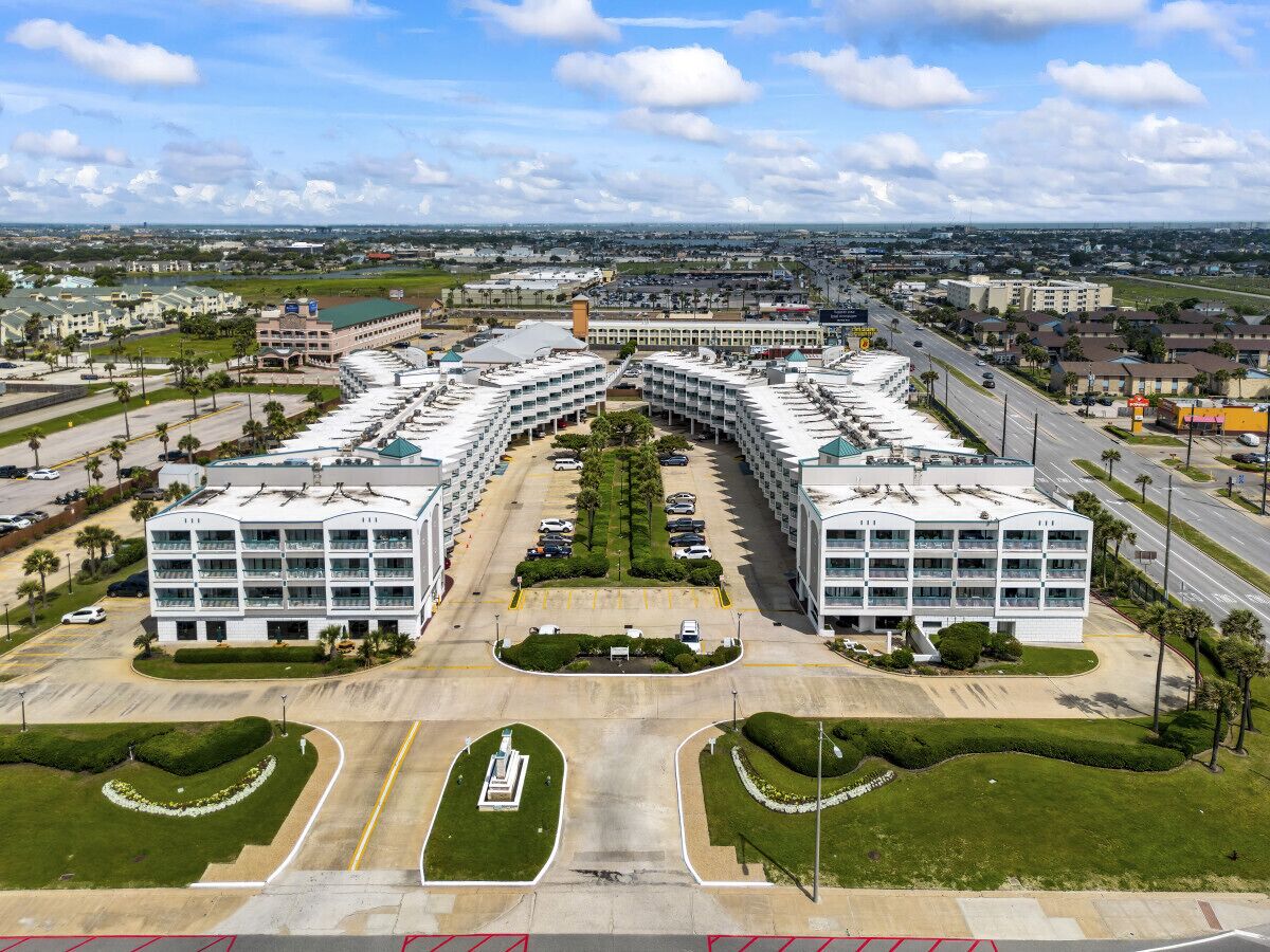 Ett stort, modernt hotell med en symmetrisk planlösning, flera parkeringsplatser och en central innergård.