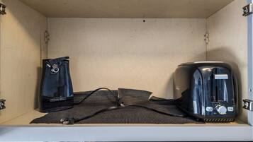 A small kitchenette with a toaster and a bag of coffee.