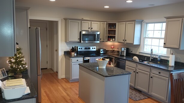 A modern kitchen with a central island, stainless steel appliances, and light gray cabinetry. - Large Beautiful quality home in a quiet subdivision.  (Lynchburg)