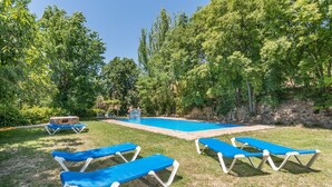 A pool area with blue lounge chairs, a small pool, and surrounding greenery. - Holiday Home 'Casa Rural La Roca' with Mountain Views, Shared Pool and Wi-Fi (La Zubia)