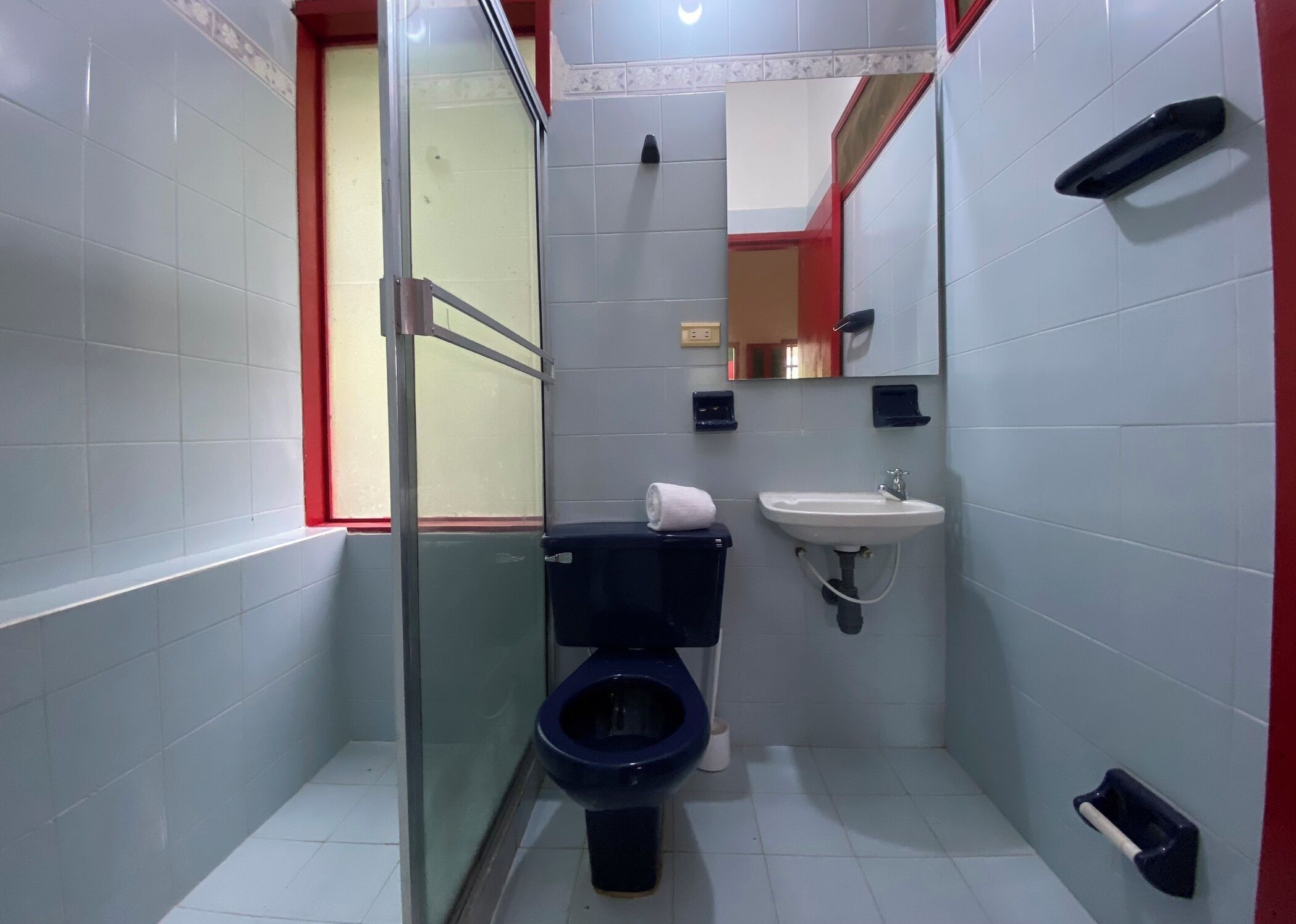 Ein kleines Badezimmer mit Toilette, Waschbecken und einer Duschkabine aus Glas.