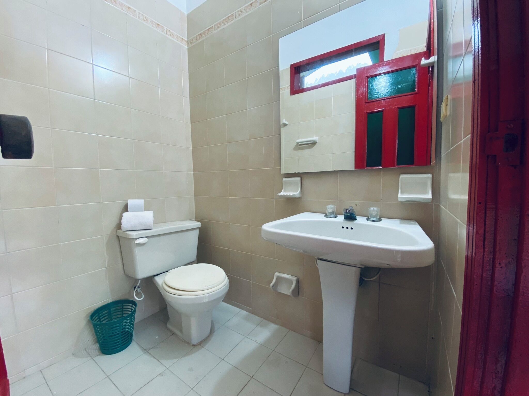 Une petite salle de bain avec des toilettes, un lavabo et un miroir.