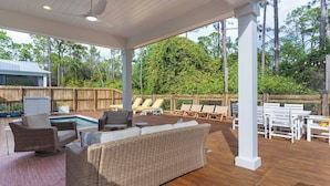 A covered outdoor patio with a pool, wicker furniture, and a wooden deck. - Priv Heated Pool + Hot Tub, Boat-friendly, Sleeps 16! Good Times by Avantstay (Santa Rosa Beach)