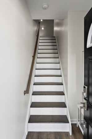 Staircase with minimalist design, featuring white steps and dark risers.