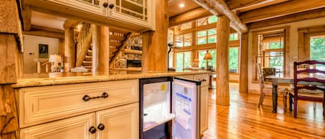 A kitchen with wooden beams, a stone fireplace, and a refrigerator with a manual.