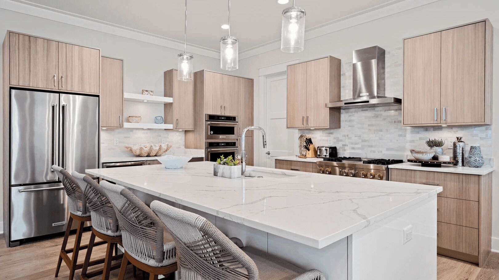 A modern kitchen with a large island, stainless steel appliances, and wooden cabinetry.