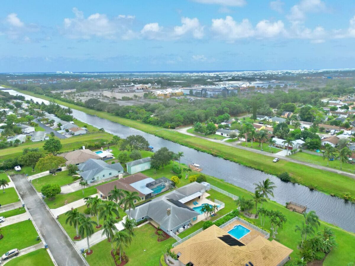 Un quartier résidentiel avec des maisons, une rivière et un ciel dégagé.