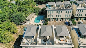 A multi-story hotel with rooftop terraces, a swimming pool, and lush greenery surrounding the property. - Emerald Paradise 2 Blocks to Beach Rooftop Patio + Pool Access Sleeps 10 (Santa Rosa Beach)